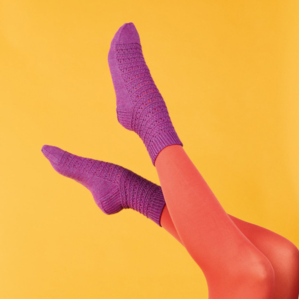 Purple knitted socks on a yellow background