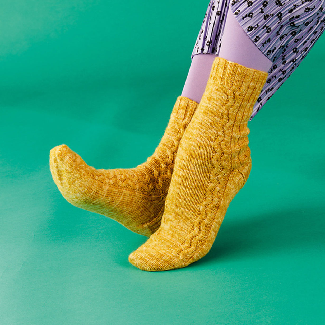Yellow knitted socks on a green background