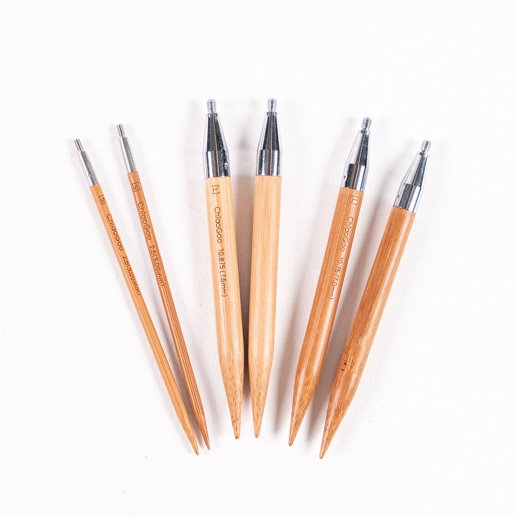 Three pairs of ChiaoGoo 4in long bamboo interchangeable knitting needle tips in sizes 3mm, 7mm and 7.5mm on a white background