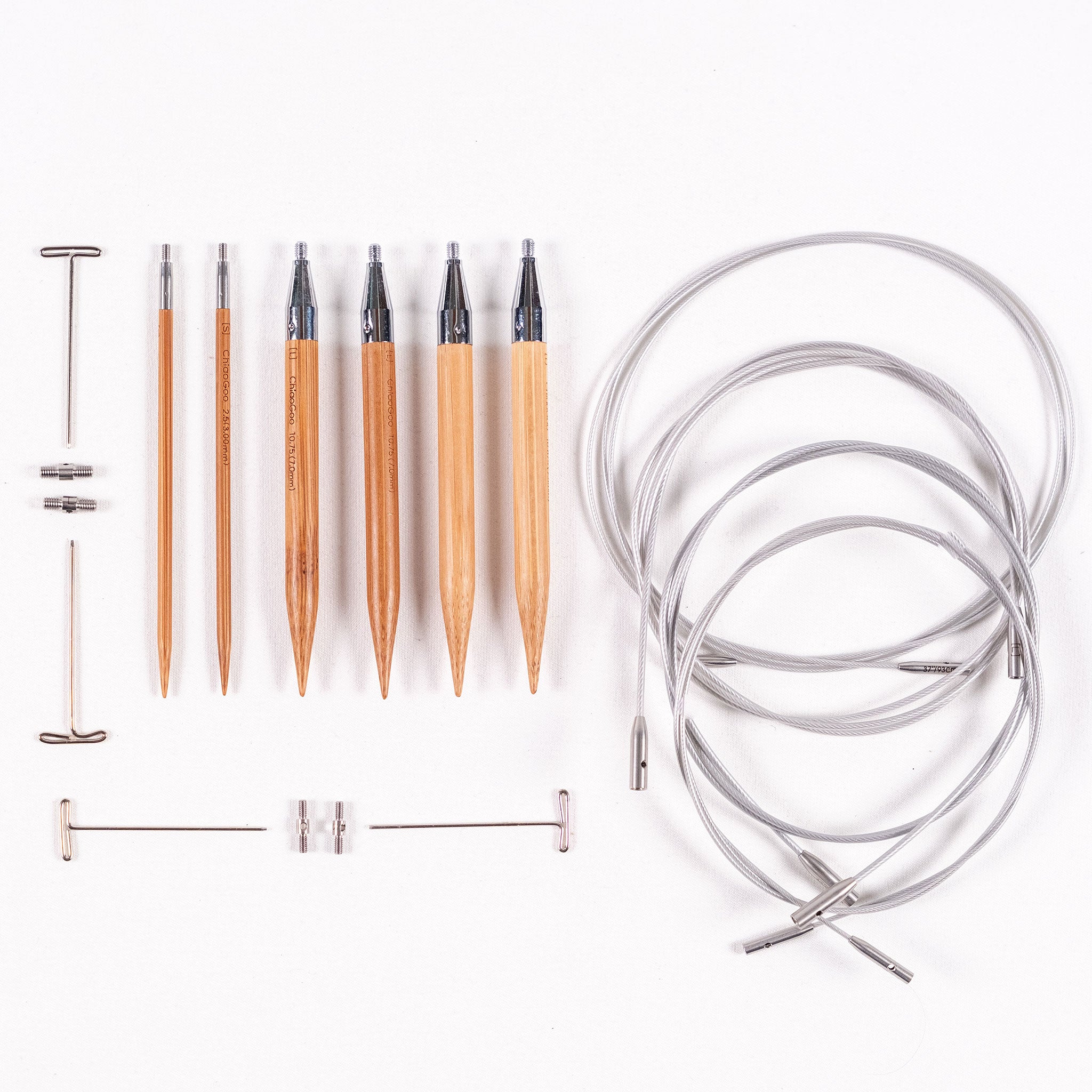 Three pairs of ChiaoGoo 4in long bamboo SPIN interchangeable knitting needle tips, four tightening keys, two small and two large cable connectors and four SWIV360 interchangeable cables with lifeline holes on a white background