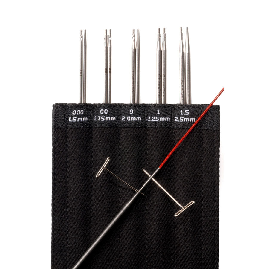 Black cotton labelled 4in MINI tip sleeve with five tips showing, together with a tip and red cable lying across the black fabric background with T-pin fastening key in the tip and in the cable