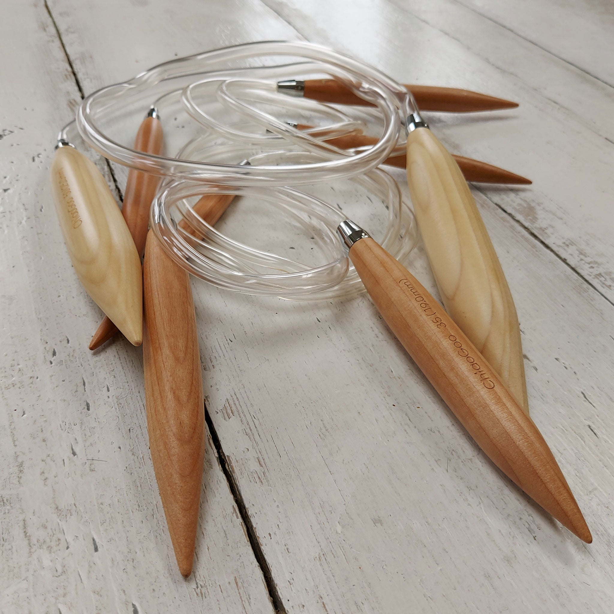 ChiaoGoo wooden knitting needles with clear cables on a light wooden surface