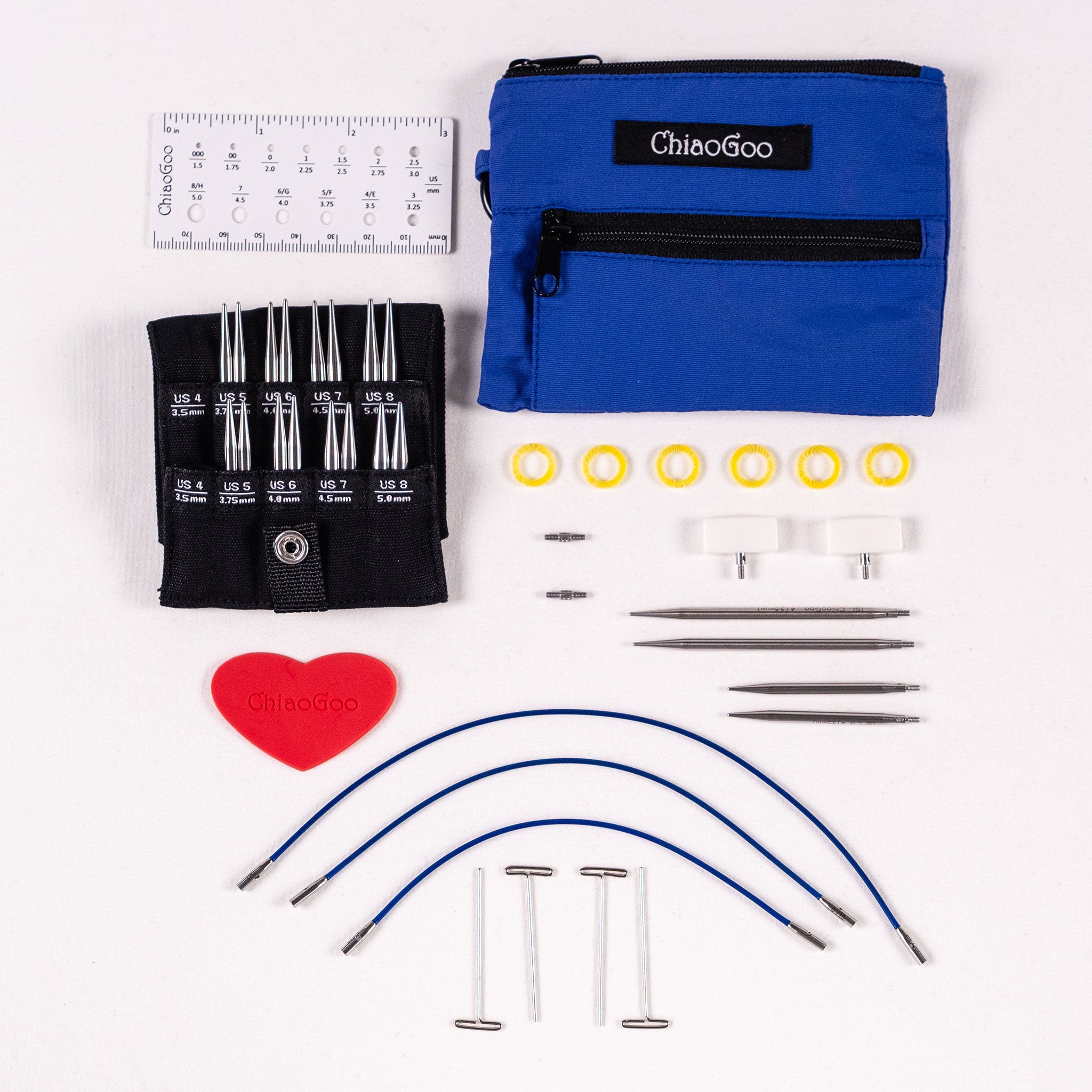 ChiaoGoo Blue Shorties set showing black labelled tip pocket with 2in and 3in tips, blue nylon zippered pouch , 5in 6in 8in x-flex small cables, red heart, white small end stoppers, six yellow stitch markers, four tightening keys, two small cable connectors, 5in long ruler needle gauge