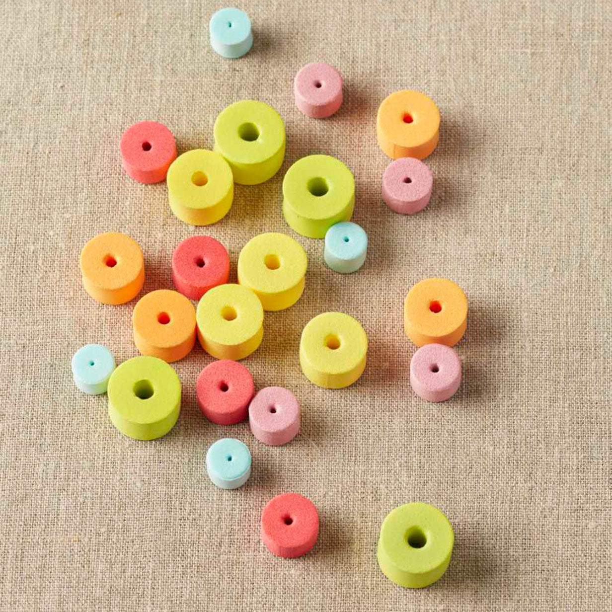 Colourful EVA foam stitch stoppers on a linen cloth