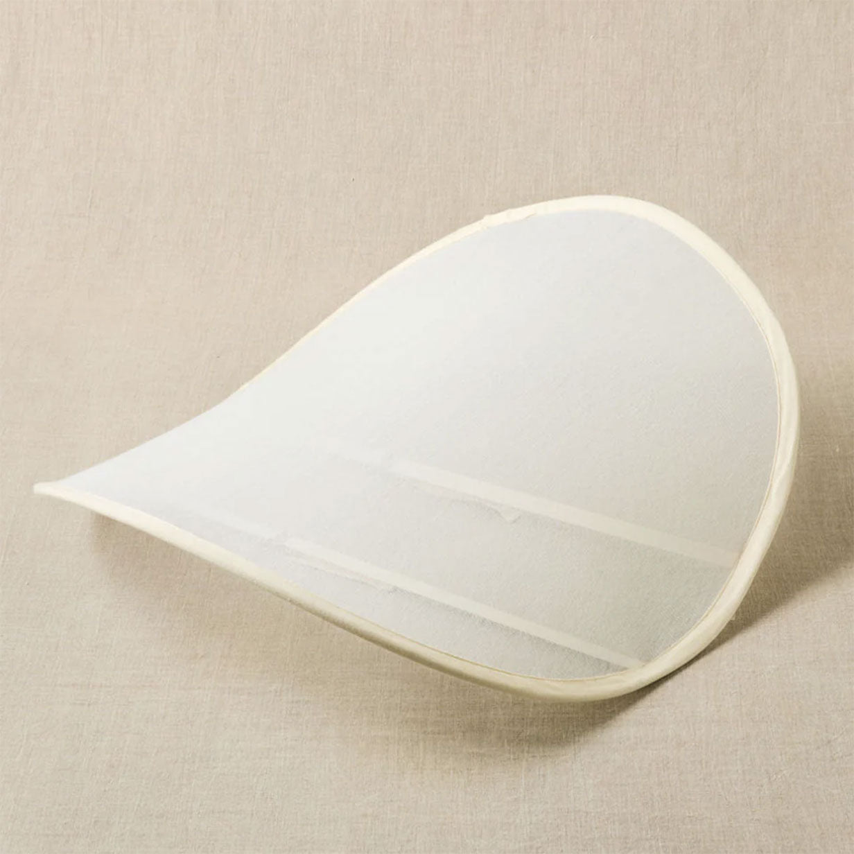 Pop up sweater dryer curved on a linen background