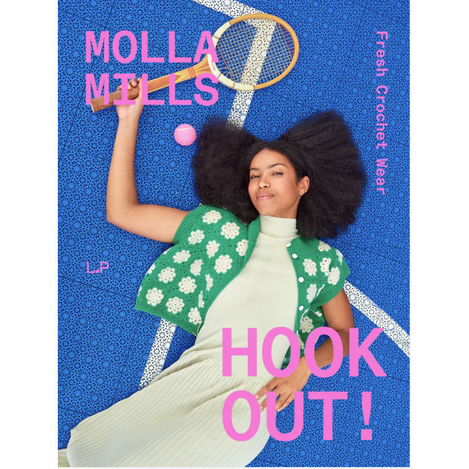 Woman lying on a blue surface with a tennis racket and ball, wearing a green crochet shawl.