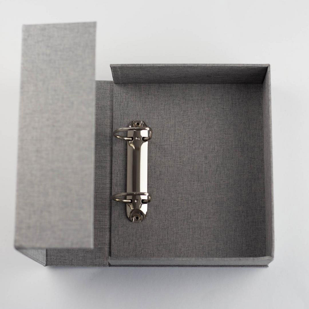 Overhead view into grey Knools needle garage ring binder, shows hinged mechanism of the cover