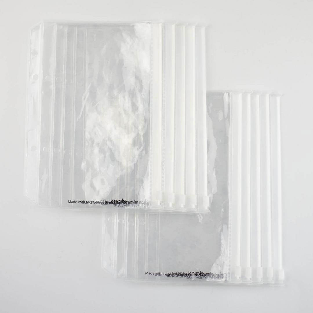 Ten clear plastic storage pockets with binder holes shown in sets of five lying on a white background