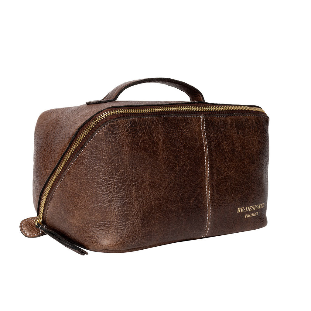 View of closed woodsmoke dark brown leather knitting project bag with brass zipper on a white background