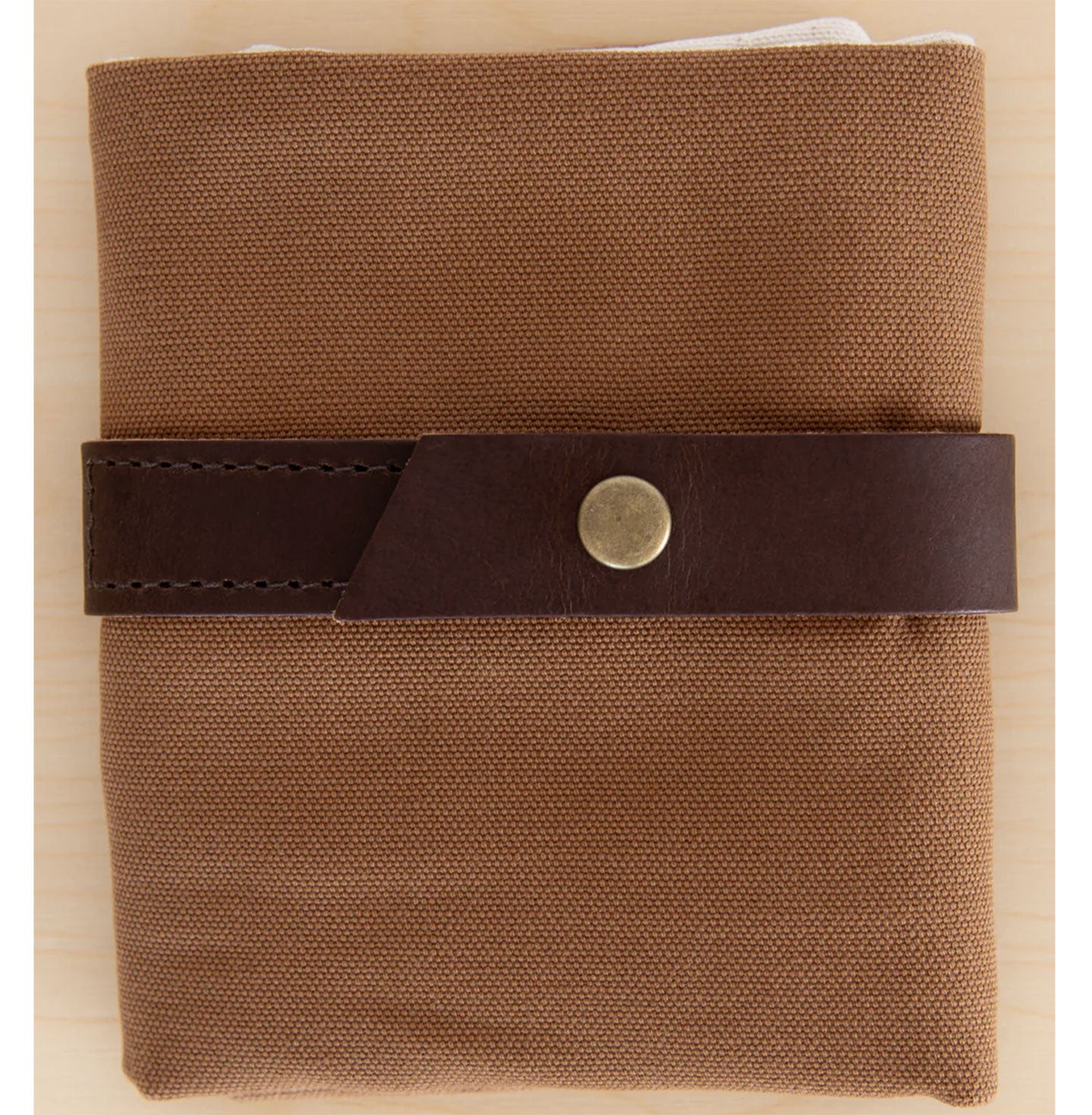 Folded camel brown canvas interchangeable case with leather strap