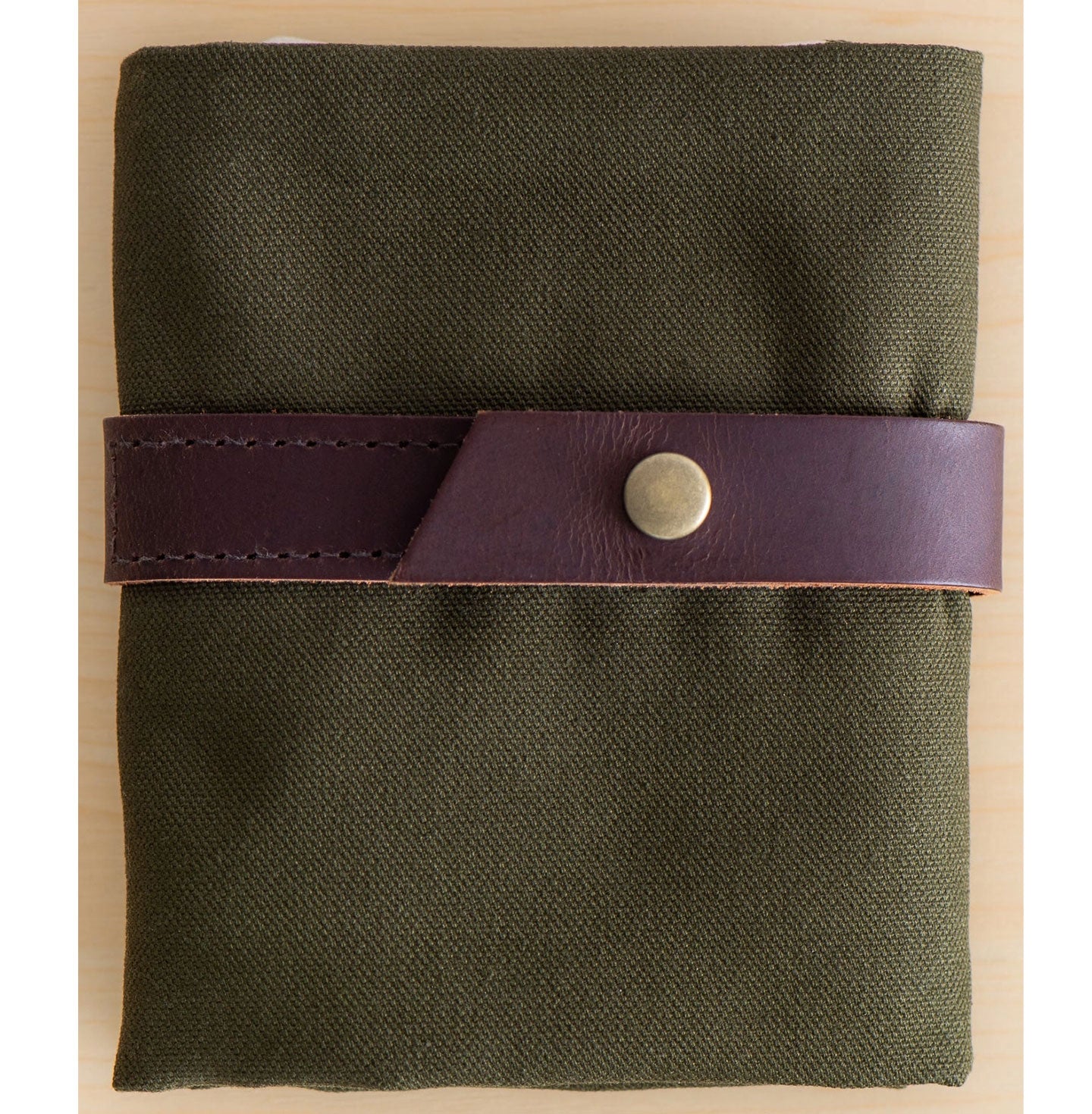 Folded olive green canvas interchangeable case with leather strap