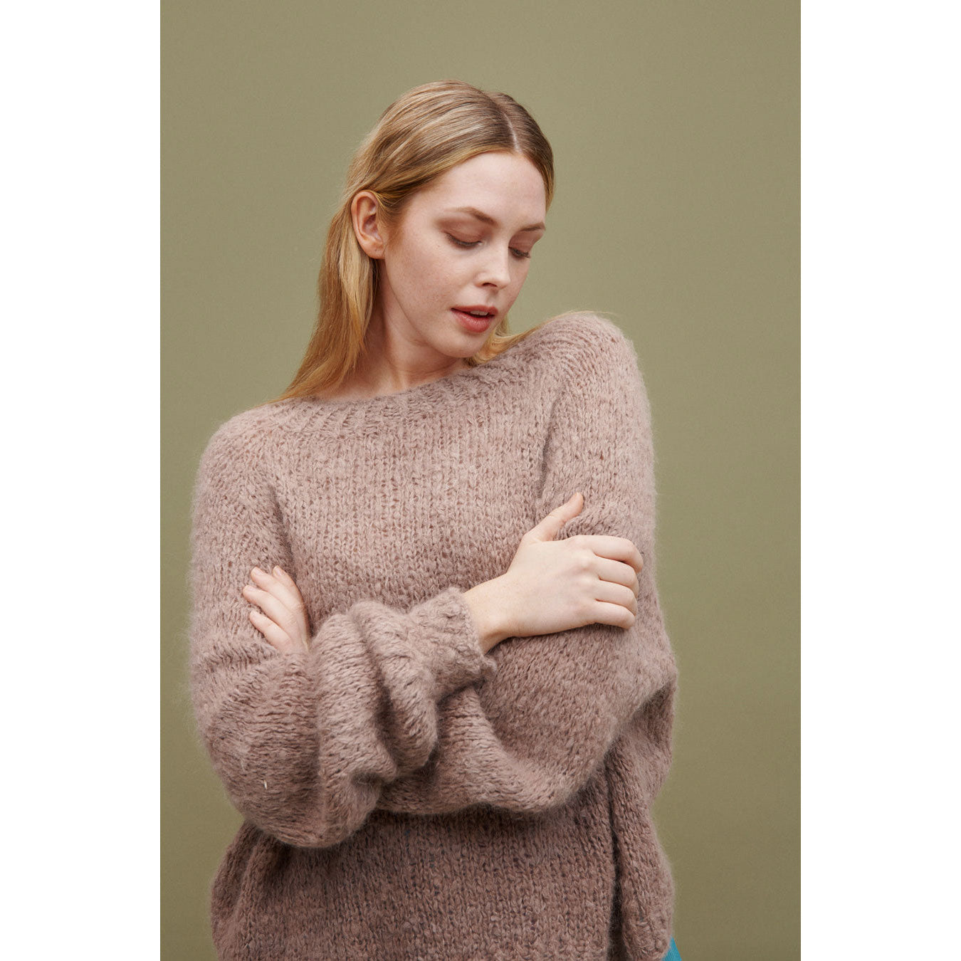 Woman wearing an oversize snuggly knitted sweater in a mauve brown shade (06 Nubo)
