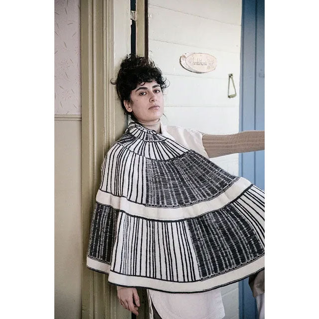 Aperture by Lauren Wallis. Person wearing a large black and white half-pi shawl with reversible colourwork. 