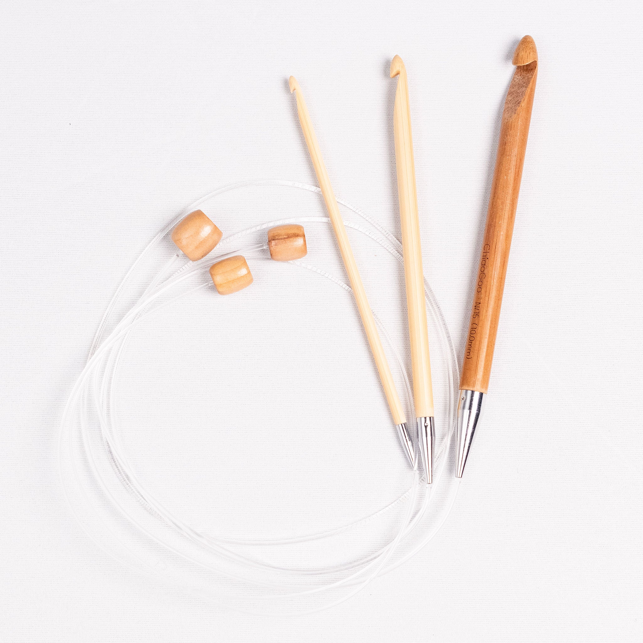 Group of three bamboo 32in long flexible tunisian hooks showing clear nylon cables coiled into a circle