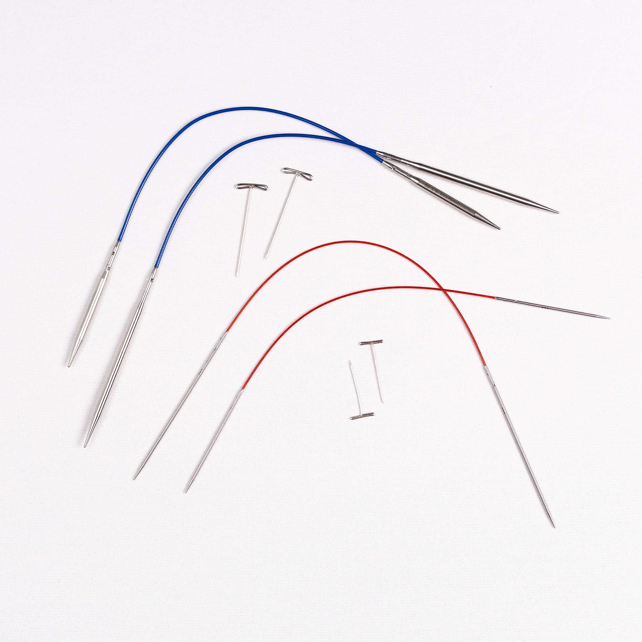 Set of metal needles with blue and red cables on a white background