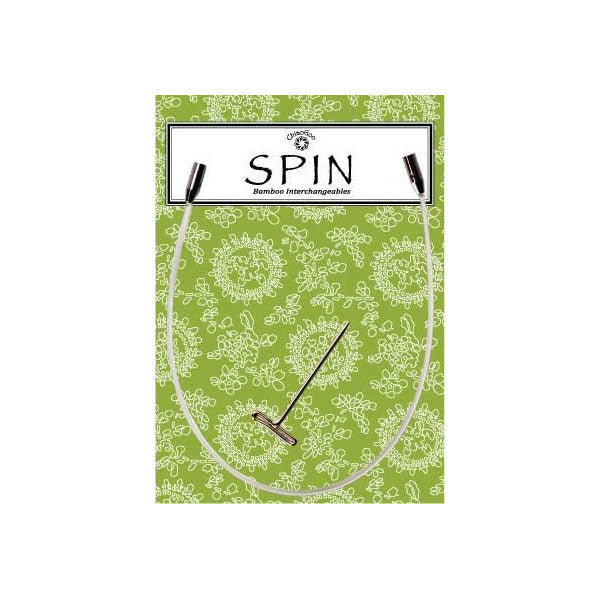 Product packaging for SPIN interchangeable knitting needle cable, a clear nylon cable with stainless steel connectors placed on a green floral patterned background