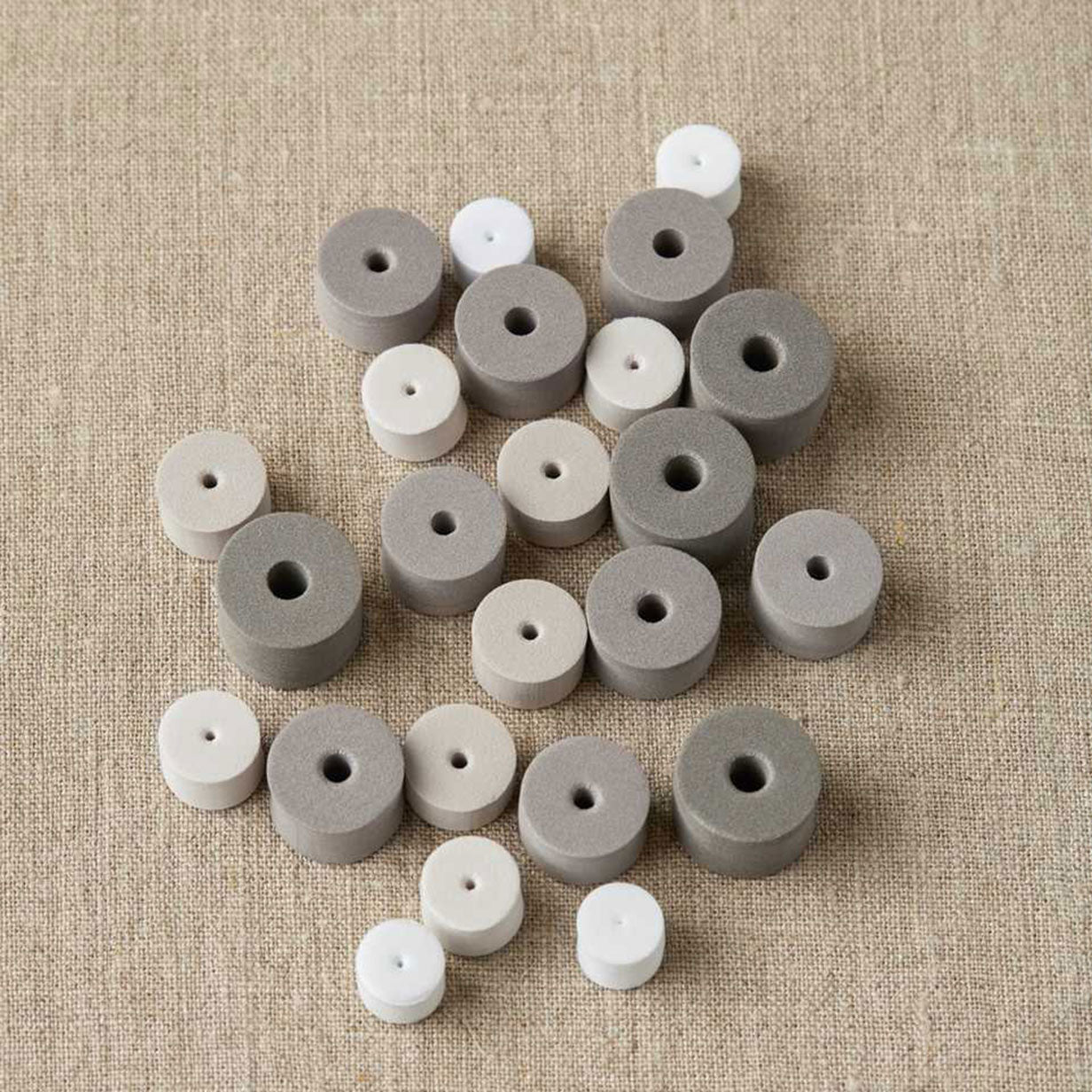 Grey EVA foam stitch stoppers on a linen cloth