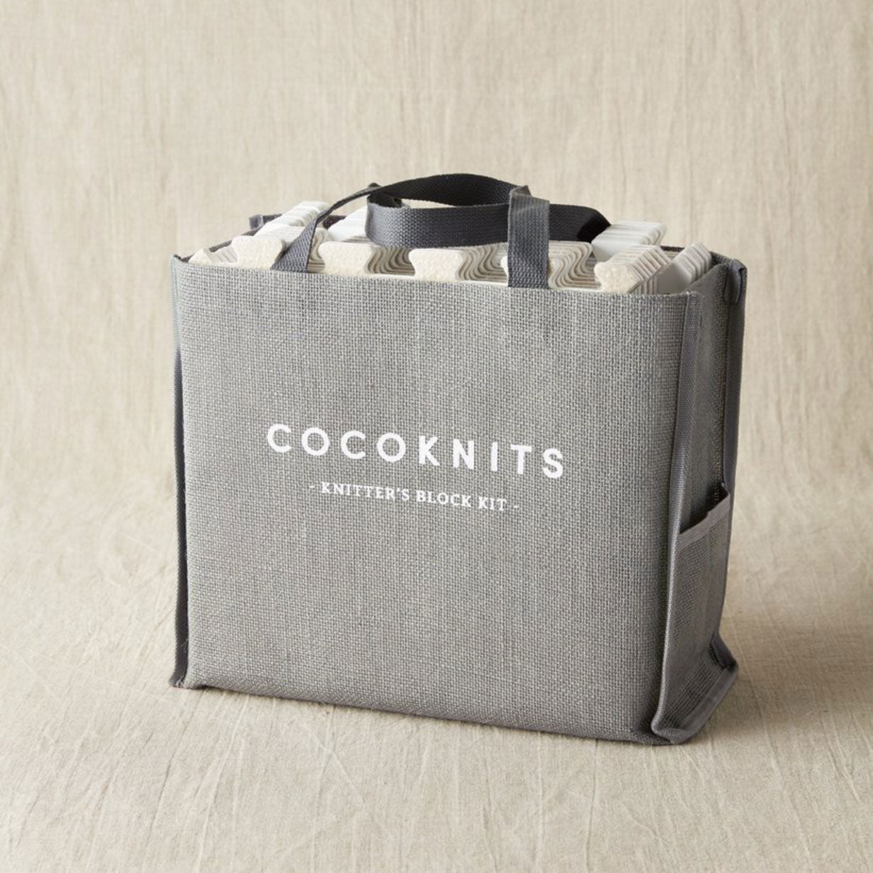 Grey jute storage bag with Cocoknits logo and - Knitter's Block Kit - printed in white on face of bag