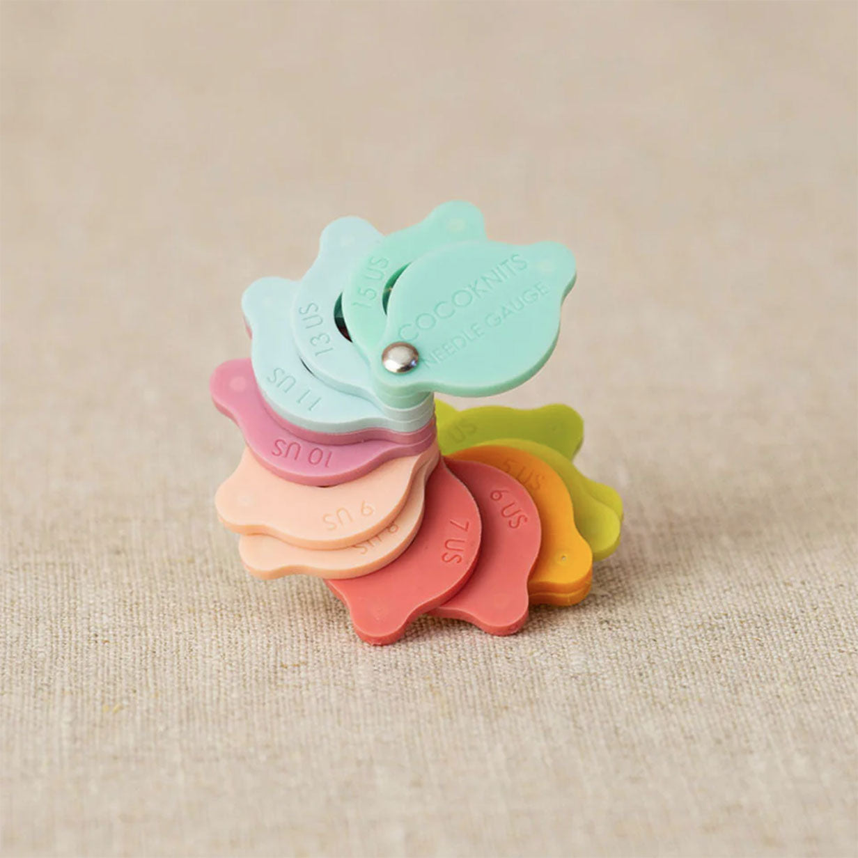 Cocoknits needle sizer gauge shown in a fan of sizes