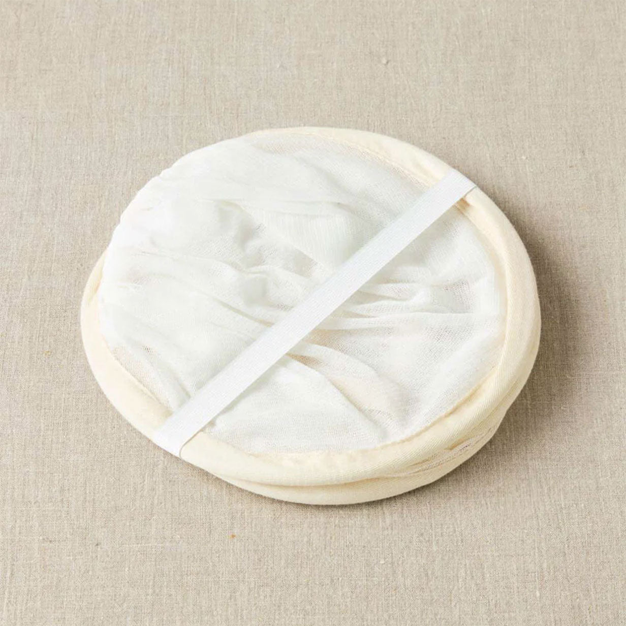 Pop up sweater dryer shown in coiled state with strap securing it 