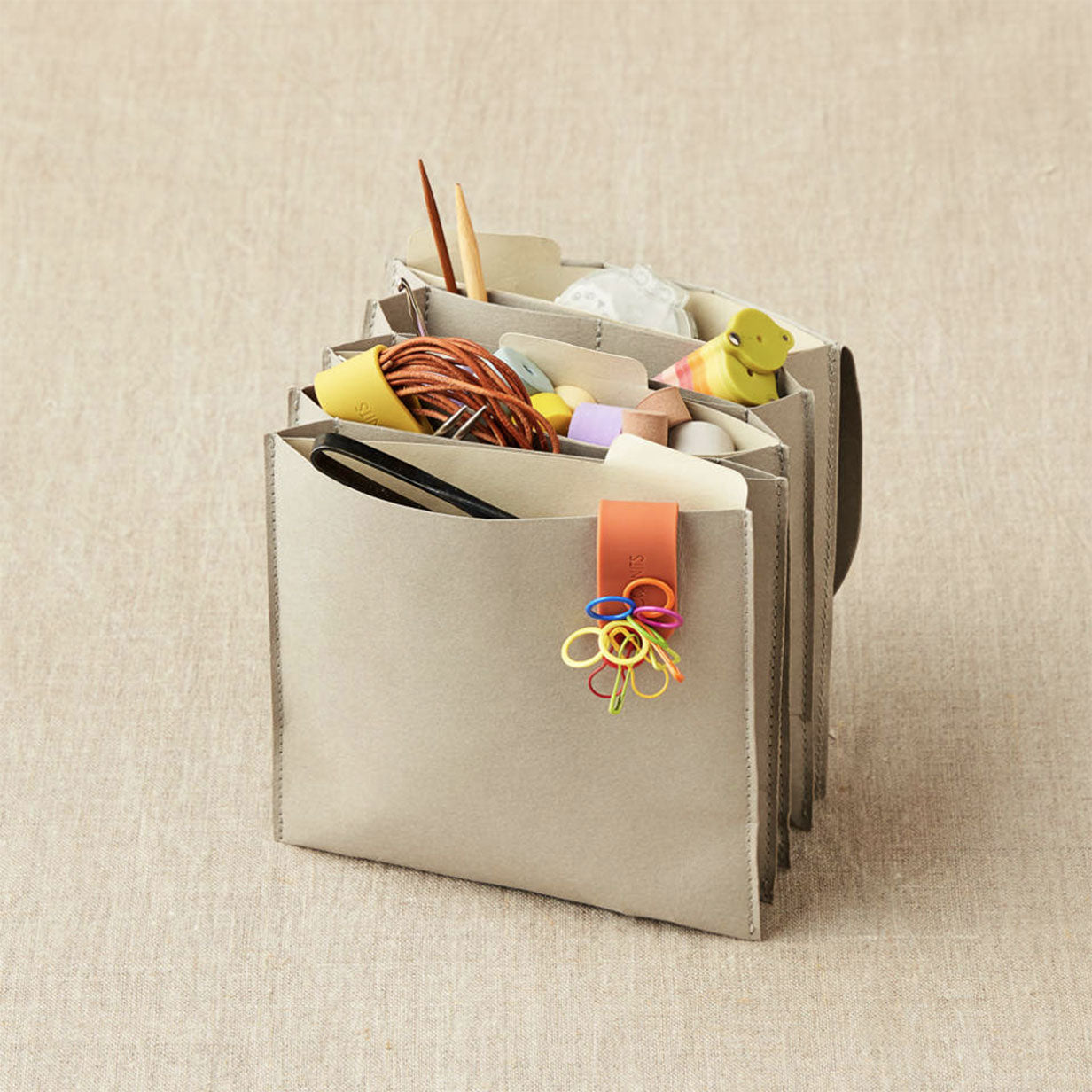 Cocoknits grey coloured paper based miniature expanding file standing on linen background