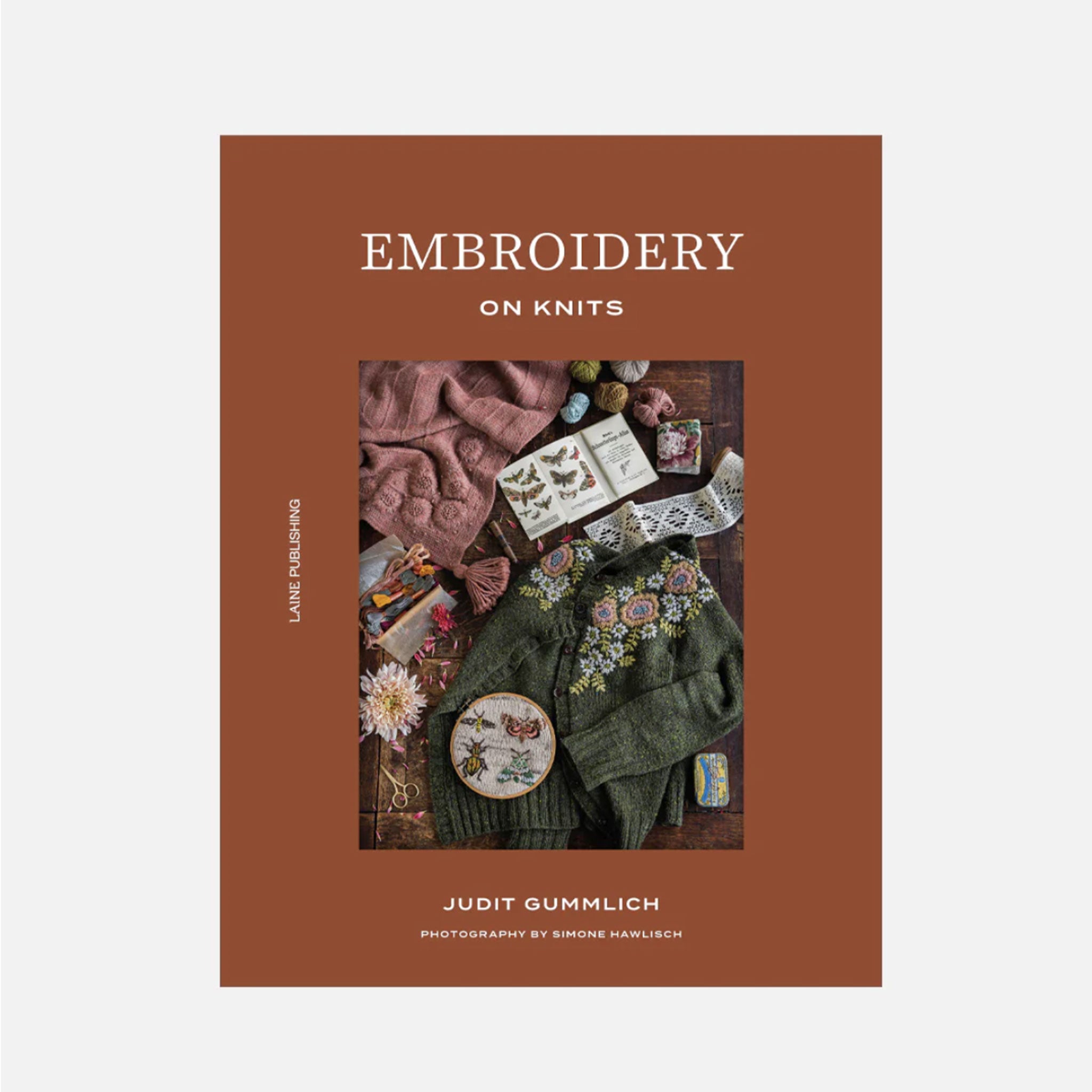 Book cover of 'Embroidery on Knits' with a brown background and text.