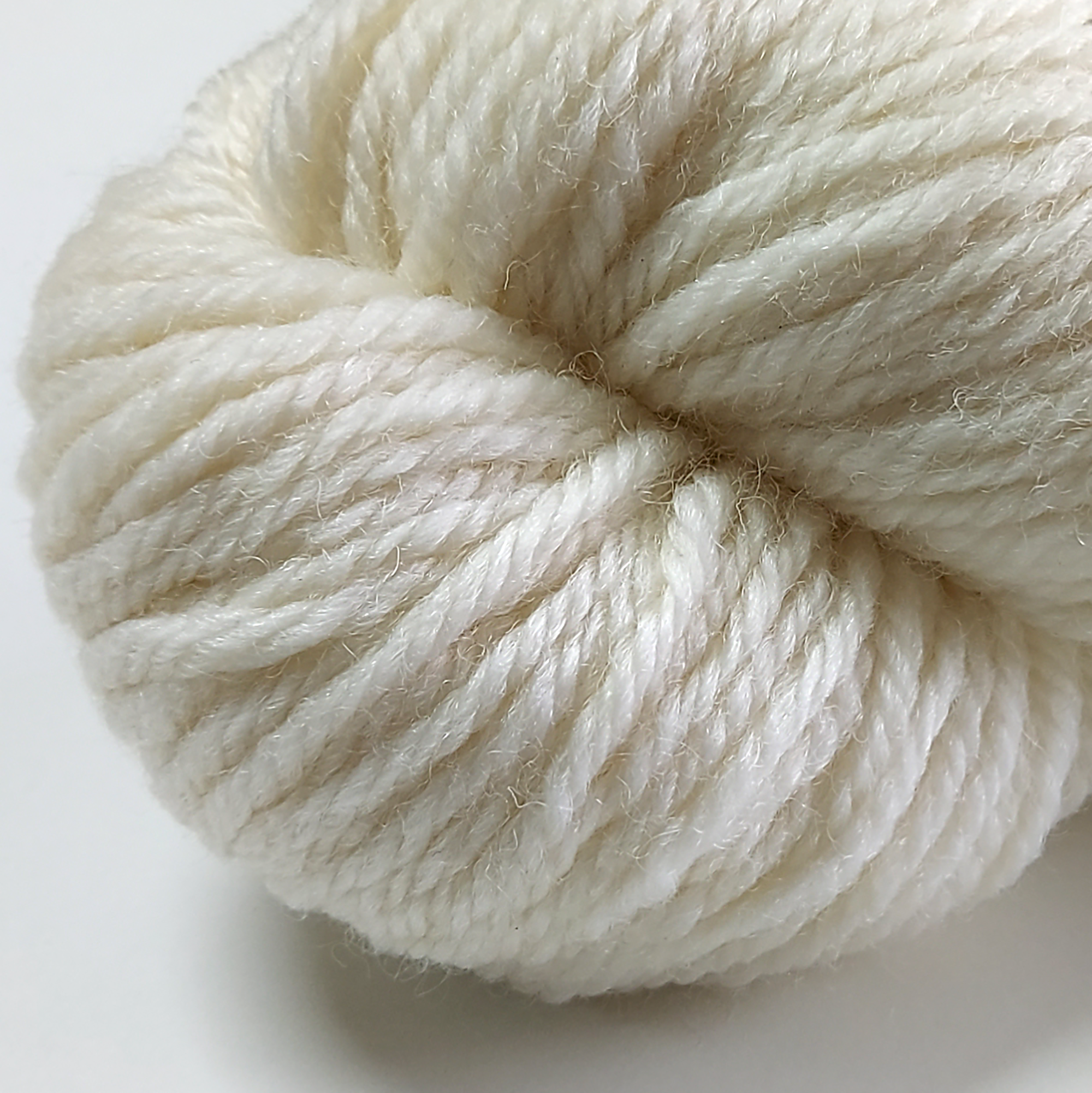 Close up view of Ivory Mist superwash chunky yarn showing twist and shine