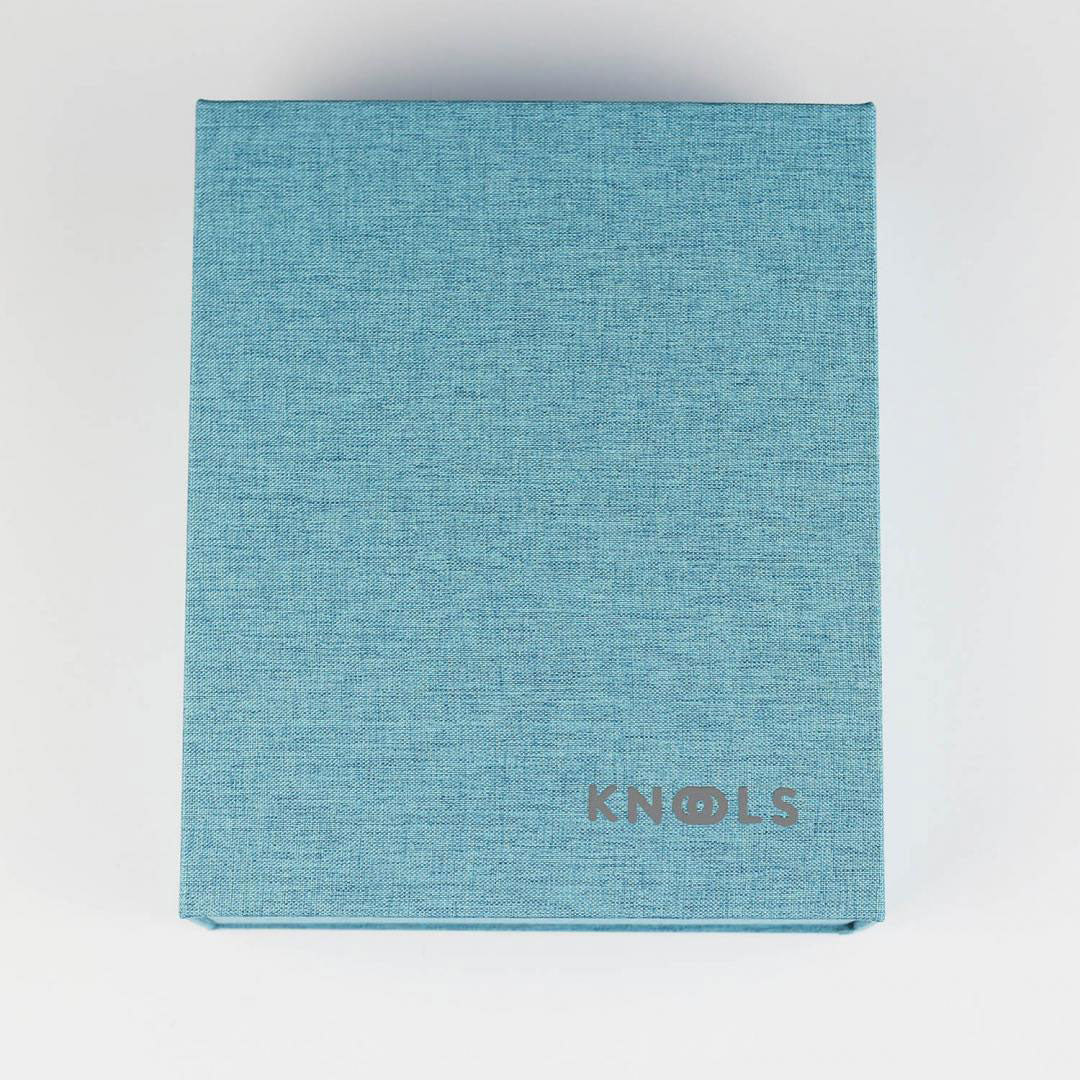 Closed turquoise fabric covered ring binder with KNOOLS logo