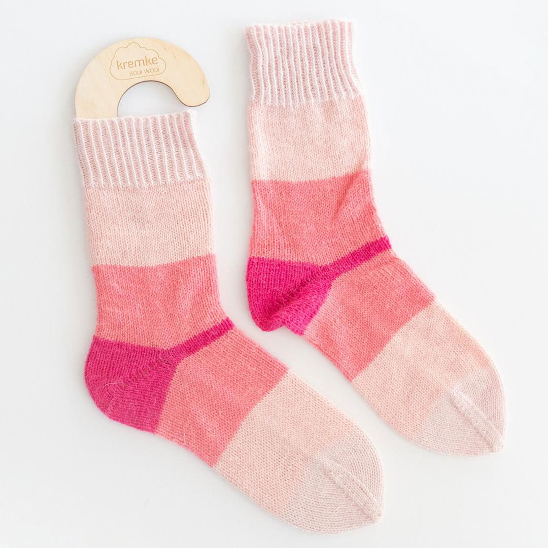 Pair of pink and red striped socks on a white background