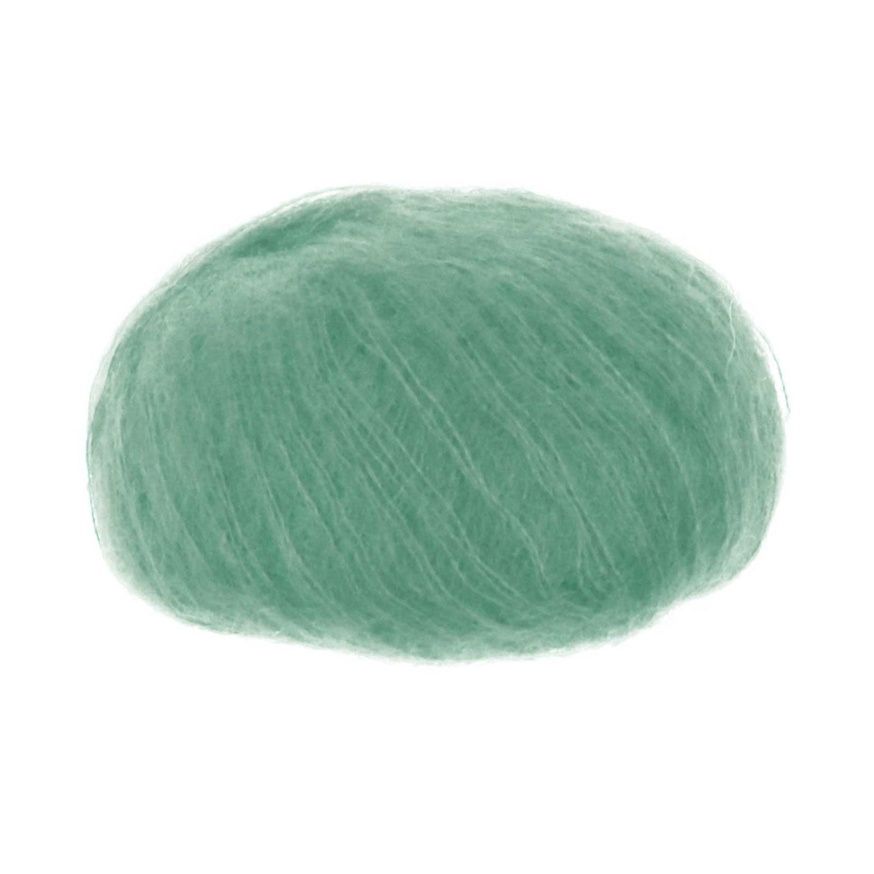 A ball of silk mohair blend yarn in a celadon green shade