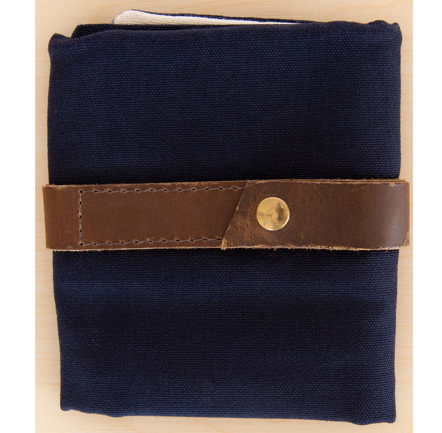 Folded navy blue canvas interchangeable case with leather strap